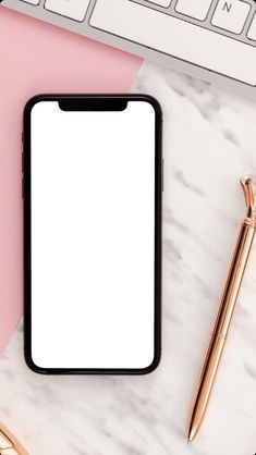 an iphone with a white screen sitting on top of a desk next to a keyboard