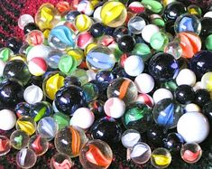 a pile of glass marbles sitting on top of a red carpet