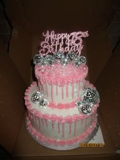 a pink and white birthday cake in a box