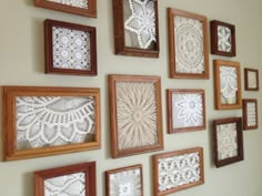 there are many frames on the wall with lace doily in them and one is hanging from the ceiling