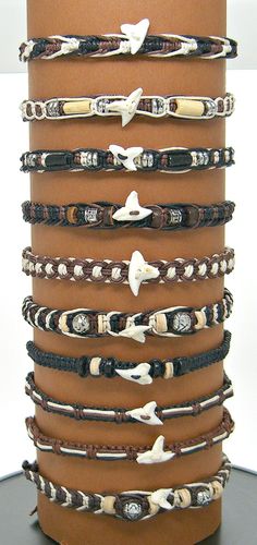 a stack of bracelets on top of a brown table next to a white wall