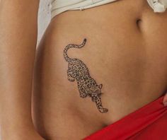 a woman's stomach with a tattoo of a leopard on the side of her belly