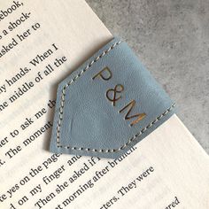 a close up of a bookmark on top of an open book with the word p & m