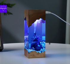 a wooden box with an image of a godzilla in the ocean on it and a cord plugged into it