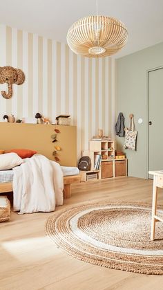 a bedroom with striped wallpaper and wooden flooring, including a round rug on the floor