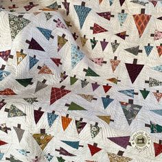 an old quilt with colorful triangles on it