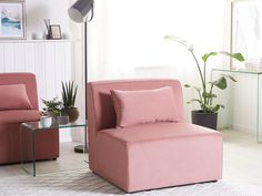 a living room with two pink chairs and a glass table