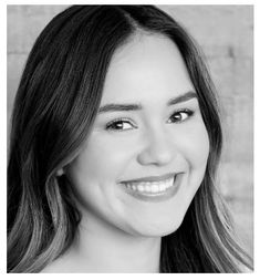 a black and white photo of a smiling woman