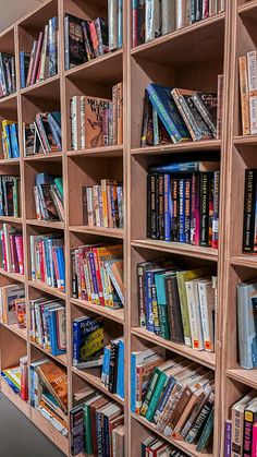 a bookshelf filled with lots of books next to a wall full of books