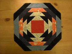 a black and orange patchwork design on a wooden surface