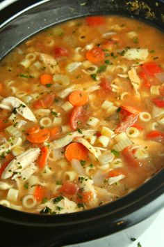 a pot filled with pasta and carrots on top of a stove