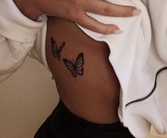 a woman's stomach with two butterflies on her side and the bottom part of her body