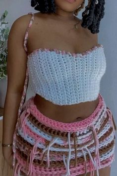 a woman wearing a crochet skirt and crop top with her hands in her pockets