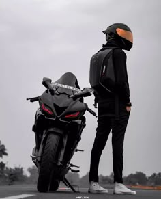 a person standing next to a parked motorcycle