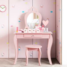 there is a vanity table with a mirror and other items on it in front of a pink wall