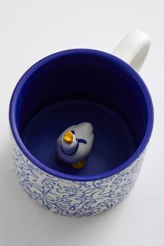 a blue and white cup with a rubber ducky in it