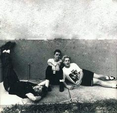 black and white photograph of two people laying on the ground next to each other with their arms around one another