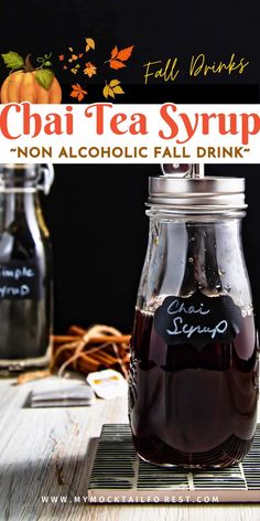 a jar filled with liquid sitting on top of a wooden table next to two pumpkins