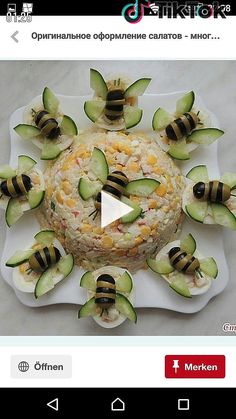 a plate with cucumbers and other food items on it, in the shape of a bee