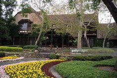 the house is surrounded by beautiful flowers and trees