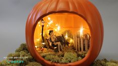 a pumpkin with a man sitting on a bench inside