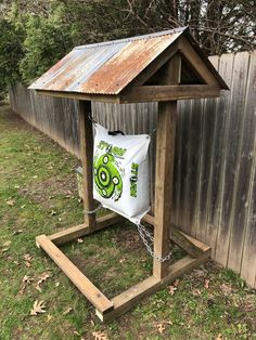 a wooden bird house with a bag hanging from it's side