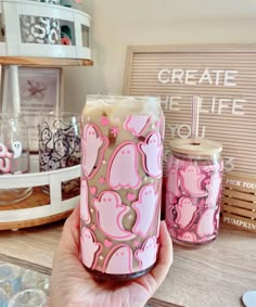 a person holding up a pink candle in front of some other items on a table