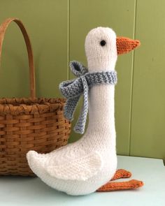 a knitted duck is next to a basket