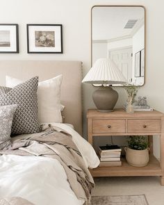 a bedroom with a bed, nightstand and mirror