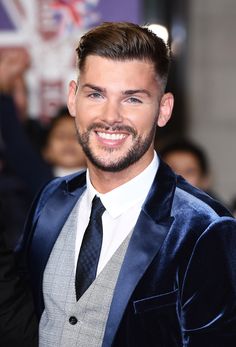 a man in a suit and tie smiling at the camera