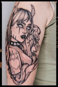 a woman's arm with a tattoo on it and an image of a demon