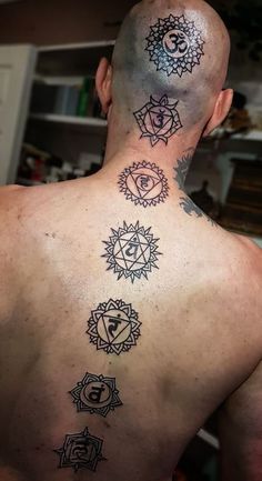 the back of a man's neck with seven chakras tattooed on it