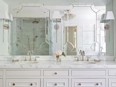 a large bathroom with two sinks and mirrors