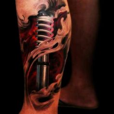 a man's leg with a tattoo on it and a microphone in the middle