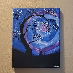 a painting of a tree with purple and blue colors on it is hanging on the wall