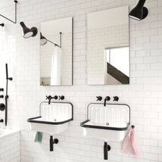 two sinks and mirrors in a white tiled bathroom