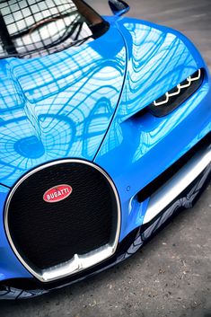 the front end of a blue bugatti sports car with an artistic design on it