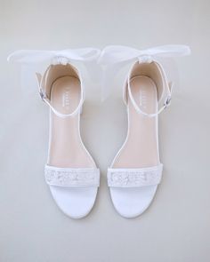 a pair of white shoes with bows on them