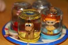 three glass jars with cartoon figures on them