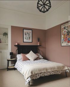 a bedroom with pink walls and white bedding