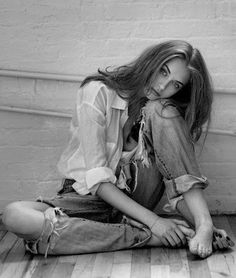 black and white photograph of a woman sitting on the floor