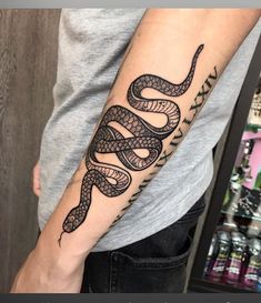 a man with a tattoo on his arm that has a snake in the middle of it