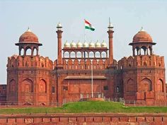 an old brick building with two towers and a flag on top