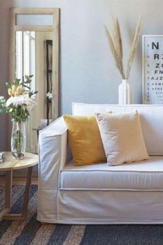 a living room filled with furniture and flowers in vases on the table next to it