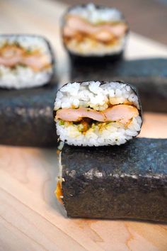 sushi rolls are sitting on a wooden table