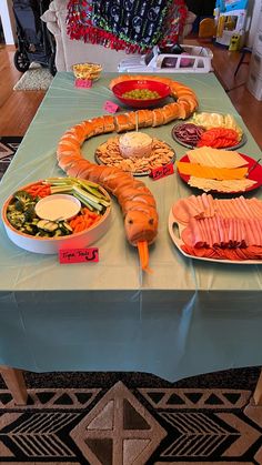 a table topped with lots of food on top of a blue table cloth covered table