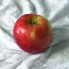 an apple sitting on top of a white cloth