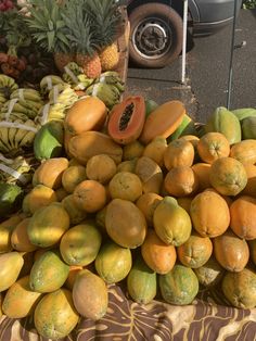 a pile of fruit sitting on top of a table next to bananas and pineapples