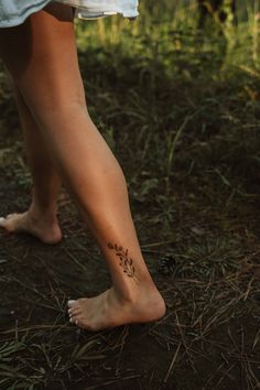 a woman's bare foot with small flowers on the bottom of her left leg