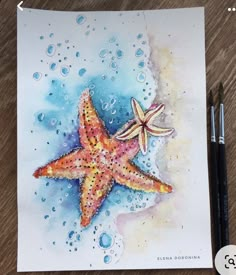 a watercolor drawing of a starfish and bubbles on a table with two markers